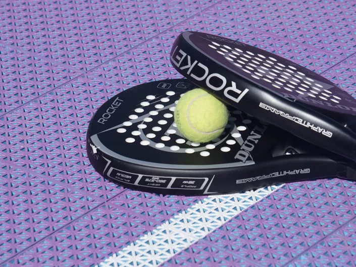 Padelutstyr med lilla i bakgrunnen.