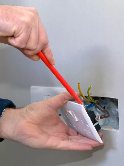 Mann som fikser stikkontakt