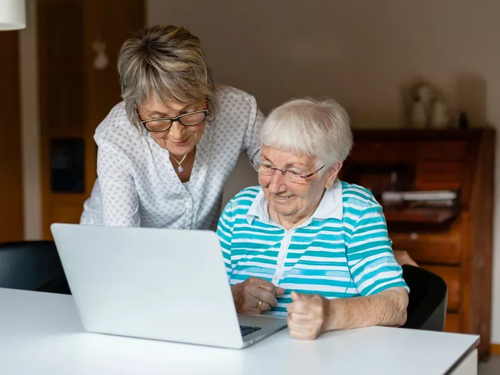 Eldre dame som blir lært hvordan nye teknologien fungerer