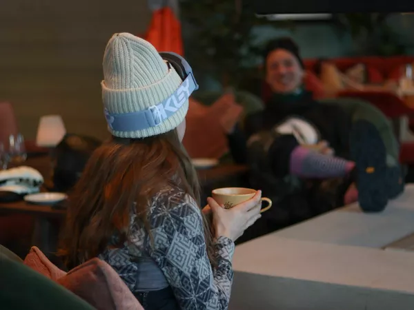 Dame med skibriller som drikker kakao