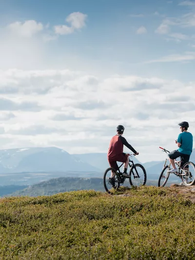 Stisykling på Golsfjellet Visit Gol Paul A Lockhart, to personer som sitter på syklene sine og ser utover fjellet.