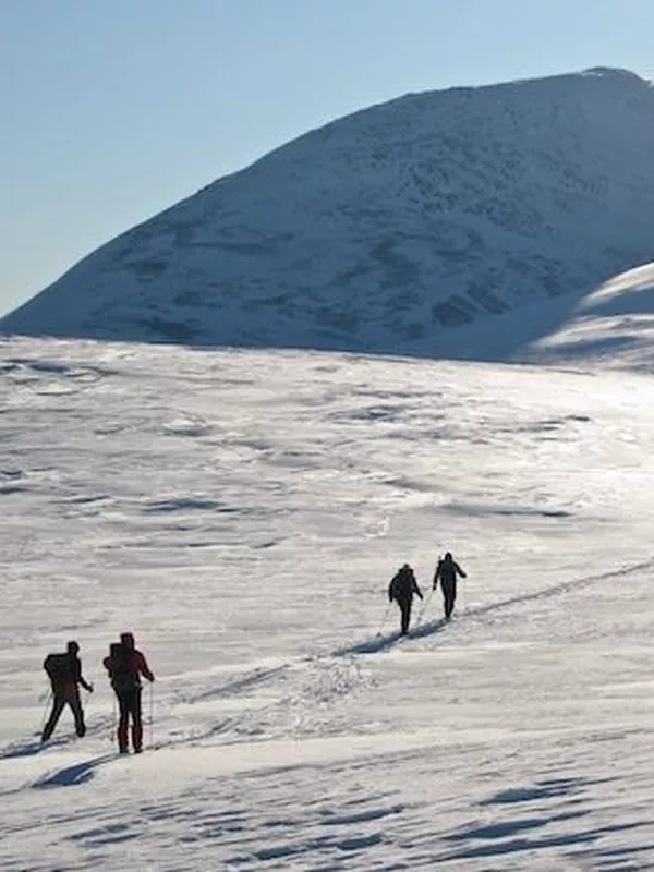 Topptur bilde fra avstand, med mennesker som går oppover i fjellet.