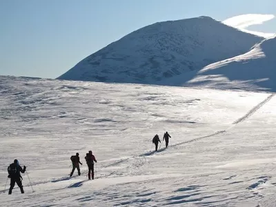 Topptur bilde fra avstand, med mennesker som går oppover i fjellet.