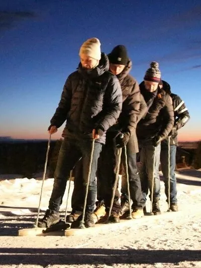 En gjeng med menn som går på pinneski sammen