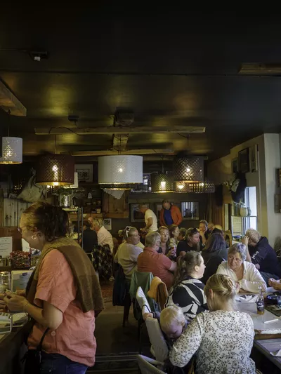 Avstandsbilde av alle folkene inne på flattbrøbakeriet, som hygger seg.