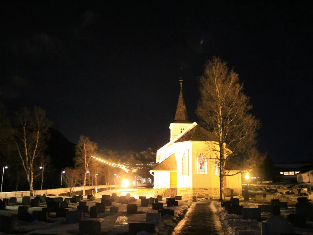 Bilde av en opplyst kirke på kvelden