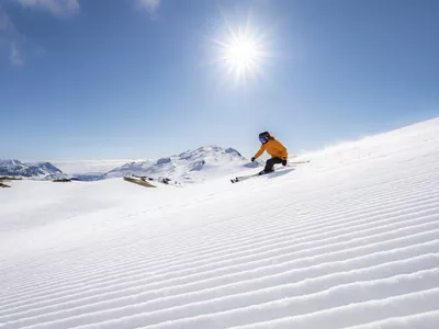 Skikjører står på ski i strålende sol