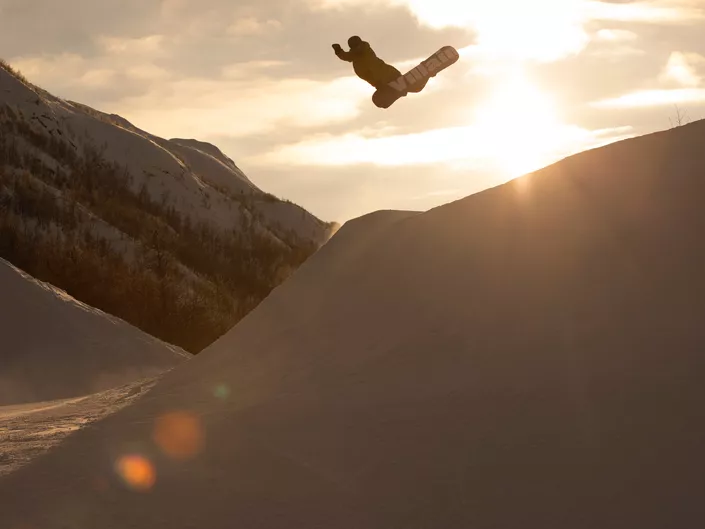 Noen som hopper på hopp med snowboard i solheisen Hemsedal