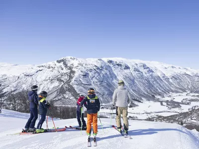 Familie som er på ski i solheisen i Hemsedal