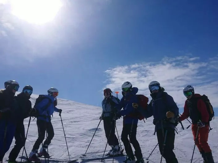 En gjeng med mennesker som er kommet på toppen og er klare til å kjøre nedover (vinter)