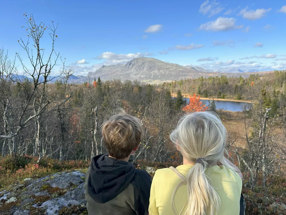 Gutt og jente sitter på fjell og ser utover Hemsedal
