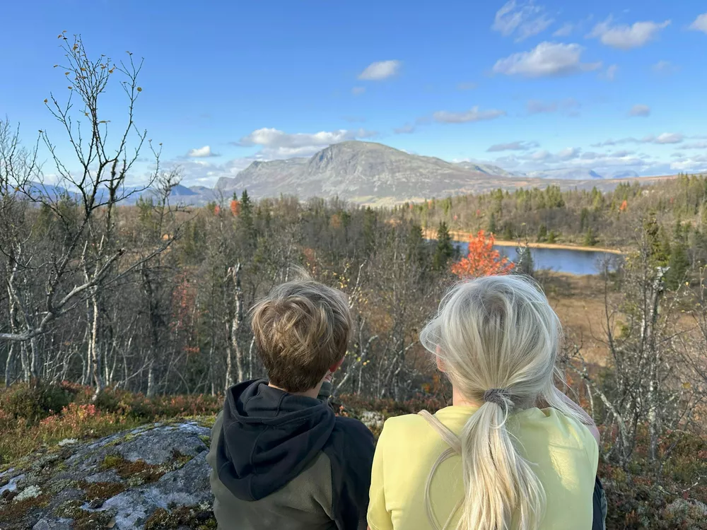 Gutt og jente sitter på fjell og ser utover Hemsedal