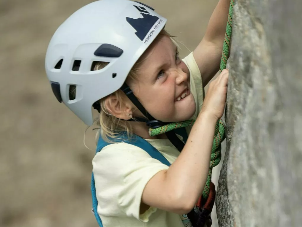 Jente som konsentrerer seg om å klatre.