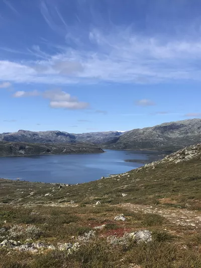 Utsikt utover fjell og vann, fint vær.