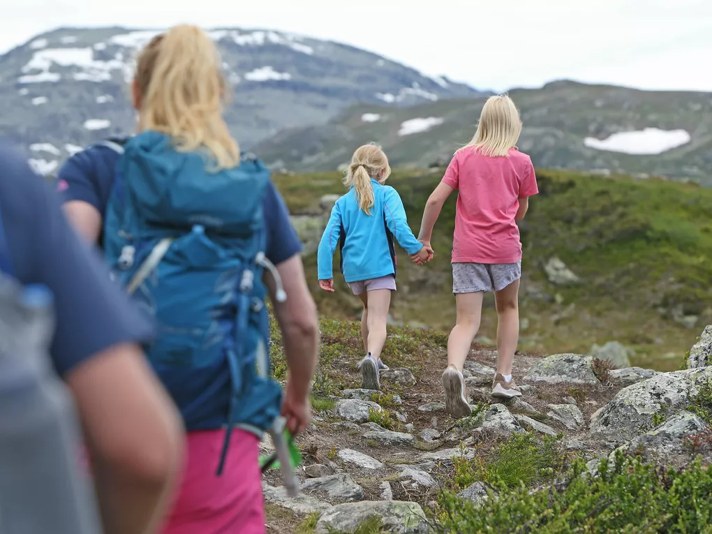 Fjelltur med familie, to jenter holder hender.