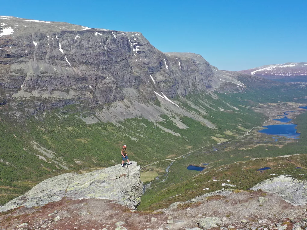 Mann på toppen av utsiktspunkt, fint vær (sommer).