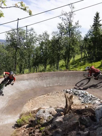 To mennesker som kjører i en skarp sving i Hemsedal skisenter