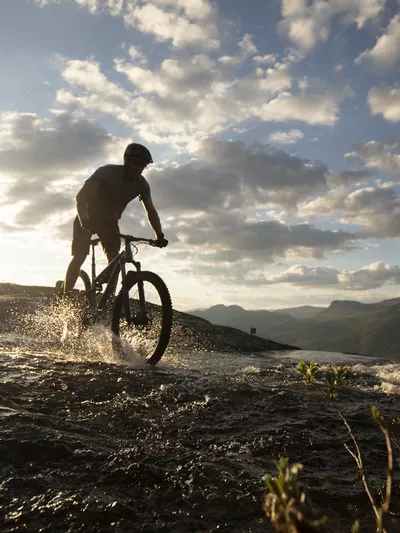 Mann som sykler oven en bekk i Hemsedal sine sykkelløyper 2