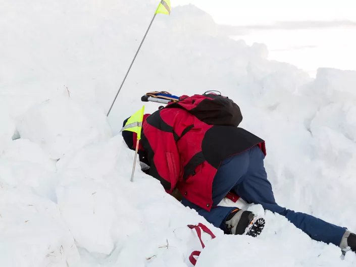 Mann som søker i snø på en skredkurs