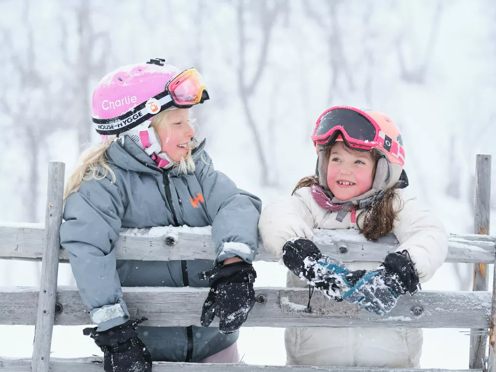 Girls hanging on the wooden fence in the mountain Visit Norway Matias Fosso Kristiansen